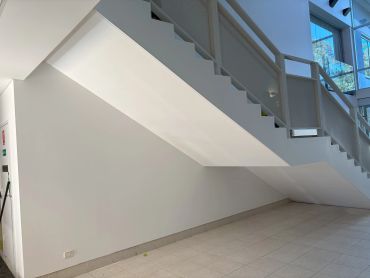 Modern staircase with white walls and tiled floor.