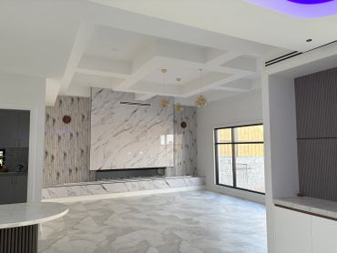 Modern minimalist living room with marble feature wall.