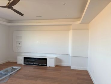Minimalist living room with built-in fireplace and wooden floor.