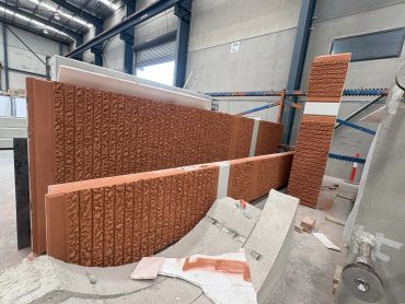 Stacked textured bricks or panels in an industrial warehouse.