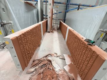 Two partially constructed brick walls with textured surfaces.
