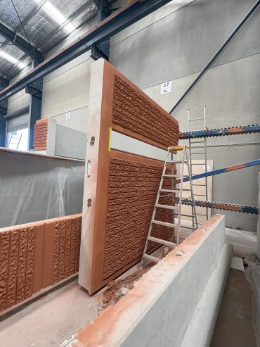 Industrial setup with a large textured panel and ladders.
