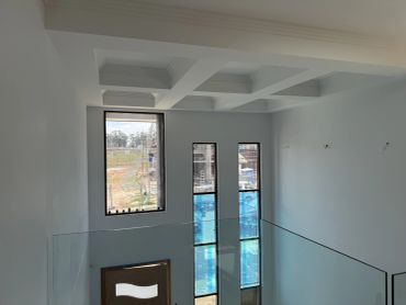 Modern room with large windows and glass railing.