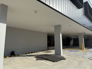 Covered parking area with pillars and wheelchair spot.