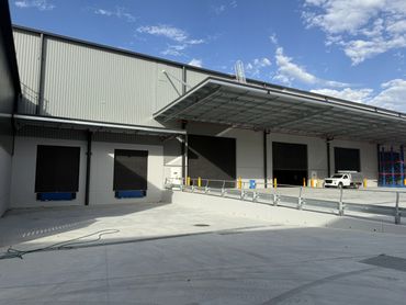 Loading dock area with closed bay doors and a white vehicle.