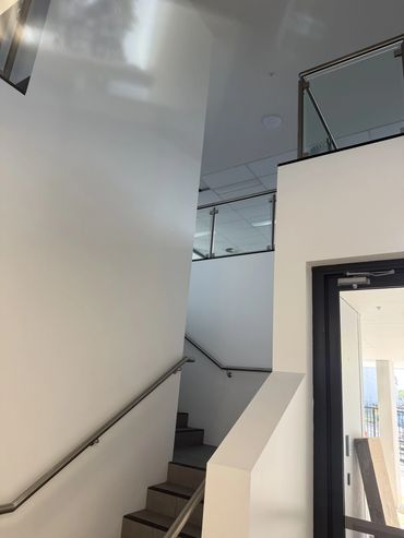 Indoor stairwell with handrails and white walls.