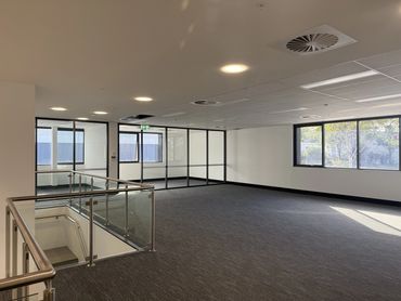 Empty modern office space with glass partitions and windows.