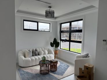 Modern living room with white sofa and large windows.