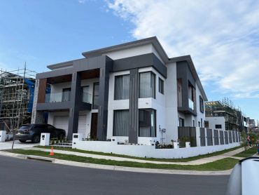 Modern two-story house with dark accents and a car parked outside.