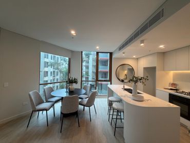 Modern kitchen and dining area with large windows.