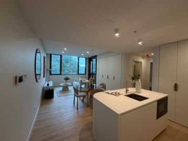 Modern apartment with an open kitchen and large windows.