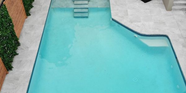 Modern outdoor pool with clear water and stone steps.