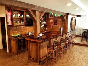 Cozy wooden home bar with stools and rustic decor.