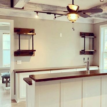 Modern kitchen bar with shelves and ceiling fan.