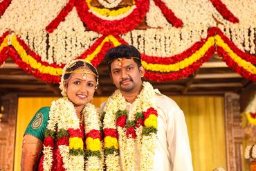 Tamil bride and groom with garlands on wedding stage in Thanjavur by Luster Pearl Media.
