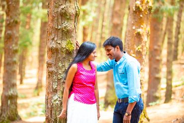 A couple sharing a tender moment in a forest.