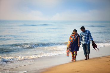 Couple walking along the seashore for pre-wedding shoot in Karaikudi by Luster Pearl Media.