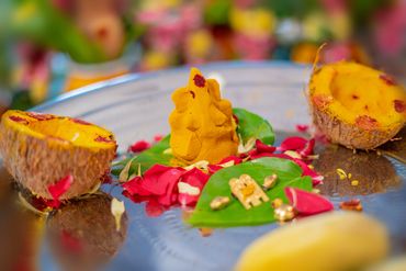 Traditional Indian religious offering with turmeric idol and betel leaves.