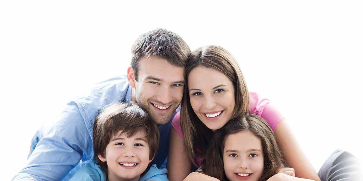 Happy family of four smiling closely together.