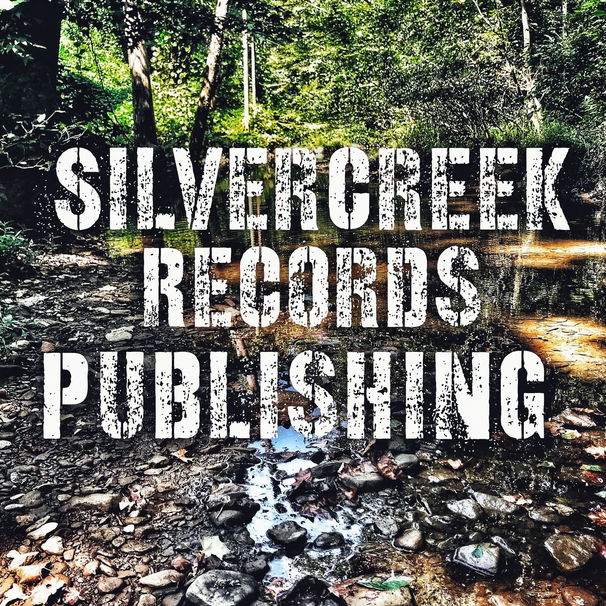 Rustic creek background with bold white text announcing Silvercreek Records Publishing.