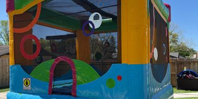 Colorful inflatable bounce house set up outdoors on a sunny day.