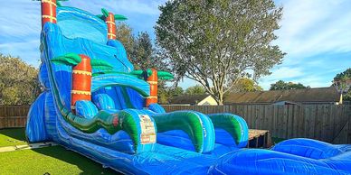 Large blue inflatable water slide set up in a backyard.
