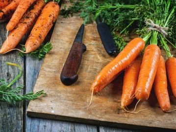 A bunch of carrots on a chopping board