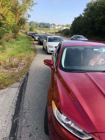 Long line of cars on the side of a road.