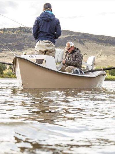 guide instructing a man fly fishing