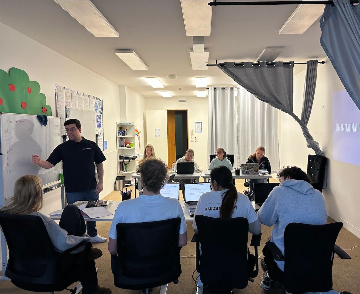 Instructor teaching financial math to a group of students in a classroom.