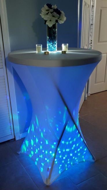 Glowing party table with blue lights and flowers.
