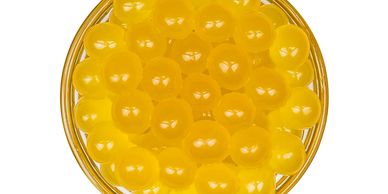 A bowl of small, translucent, yellow, popping poppers.


