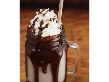 Thick chocolate milkshake in a mason jar with whipped cream and chocolate sauce.

