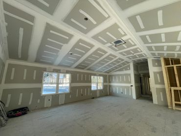 Interior of a room under construction with drywall installed.