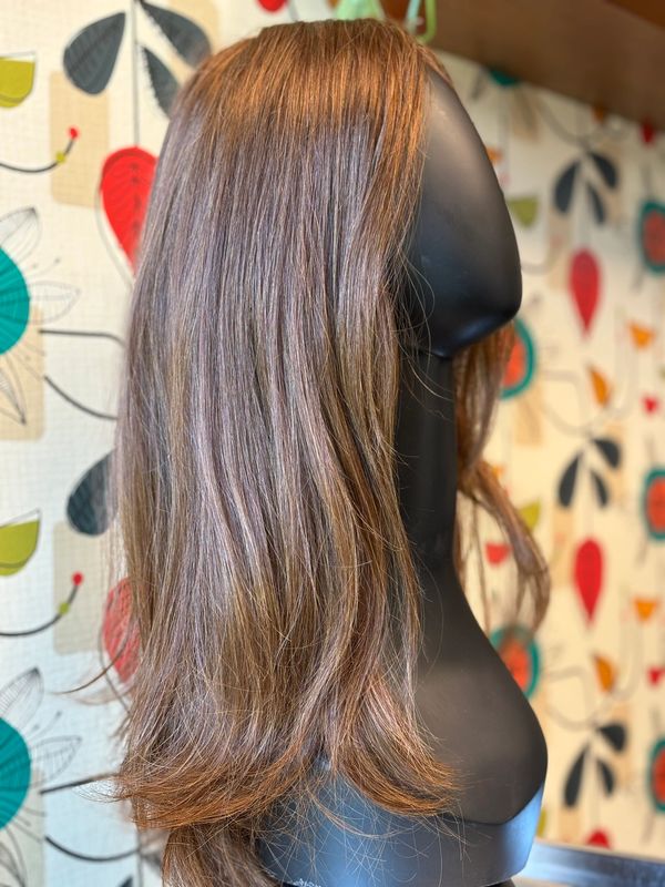 A long brown wig on a mannequin head