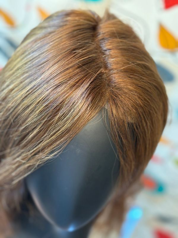 Close up of a long brown wig on a mannequin head