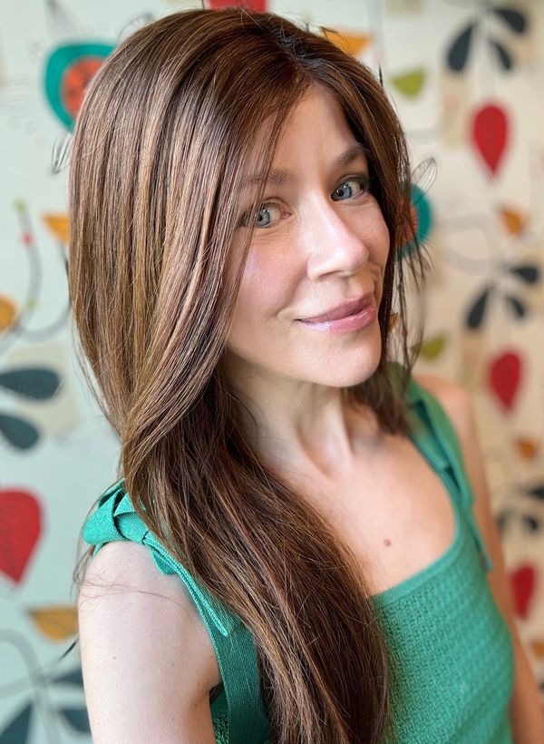 A woman wearing a long brown wig