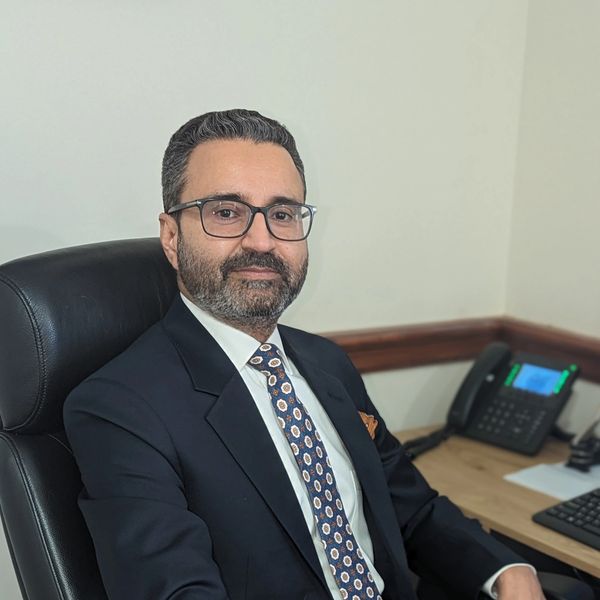Man in suit sitting at desk in office.