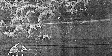 Bend Buletin photograph showing the crime scene photographer and officers standing above.