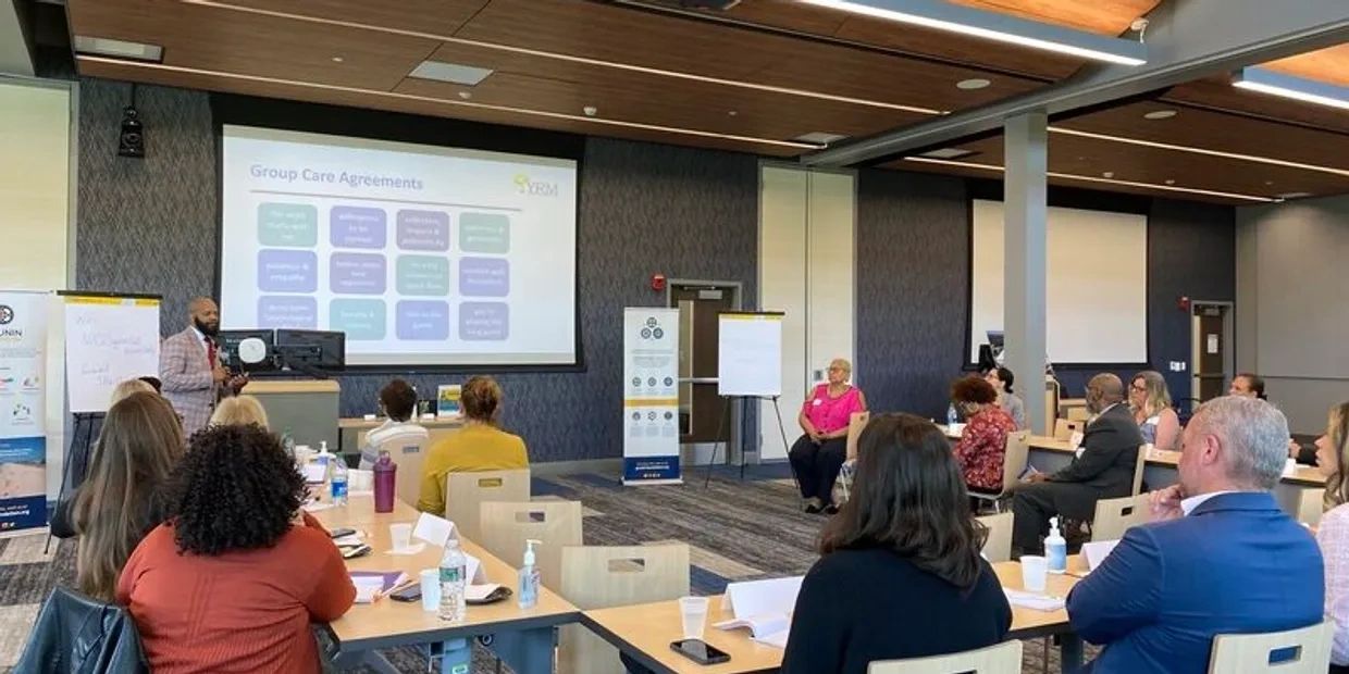 Professional training session with attendees listening to a speaker in a conference room.
