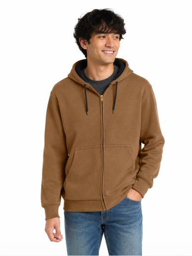 A man wearing a brown zip-up hoodie and blue jeans.