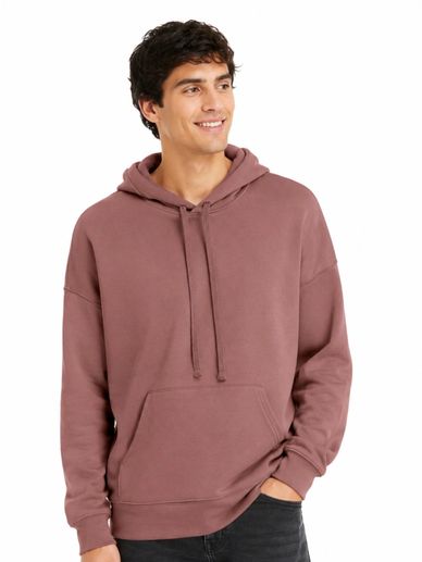 Young man wearing a mauve hoodie and smiling.