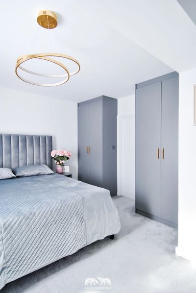 Bespoke fitted wardrobe in grey colour.
brass handles, brass lightening. soft headboard. bedroom