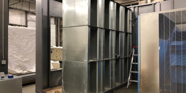 Large industrial metal ductwork in a workshop.
