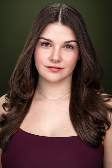 Portrait of a young woman with long brown hair and a calm expression.