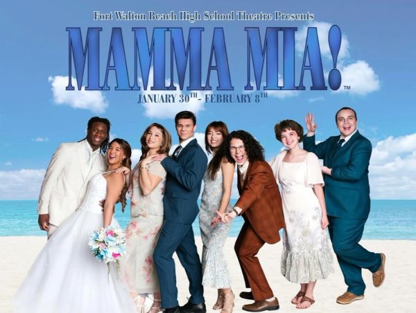 Cast of Mamma Mia! posing on a beach for the musical's promotion.