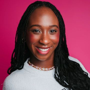 Smiling woman with braided hair against a pink background.