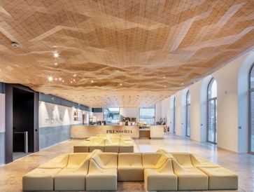 Modern lobby with wavy wooden ceiling and beige modular seating.