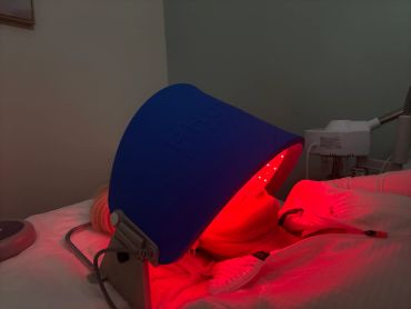 Person undergoing red light facial therapy.