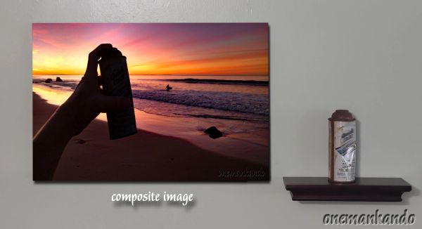 A hand holds a spray can against a colorful sunset beach backdrop.
